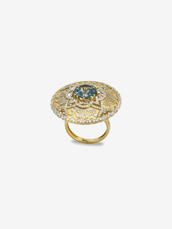 Merkezinde mavi topaz taşı bulunan, çevresi "Lâ Galibe İllallah" hat sanatı ve yoğun pırlanta dizilimleriyle bezeli 18 ayar altın yüzük.