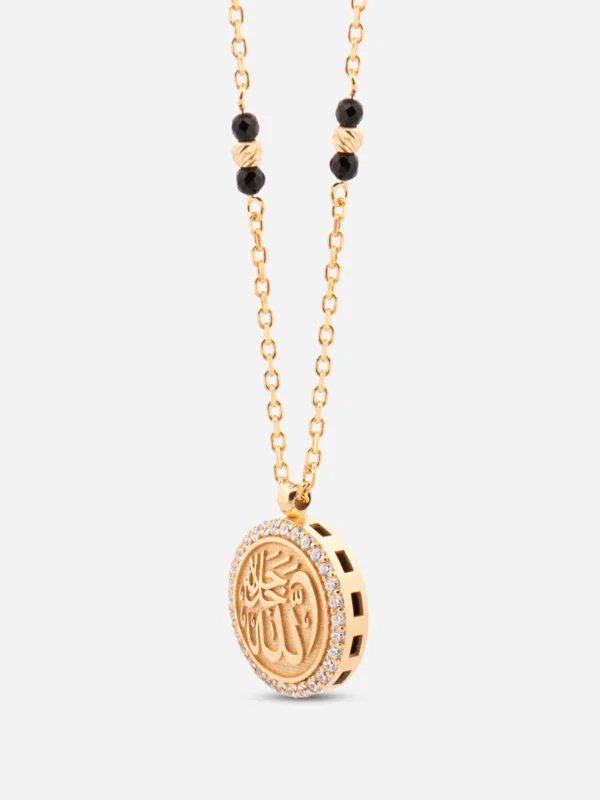 Ön yüzünde orijinal tarihi tekstil dokusu, arka yüzünde pırlanta ışıltılı taşlarla çevrili "Lâ Galibe İllâllah" kaligrafisi bulunan gümüş kolye.