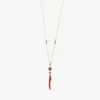 A necklace featuring an 18-karat gold chain with a circular coral pendant framed in diamonds, adorned with a delicate, vertically shaped natural red coral branch pendant below.