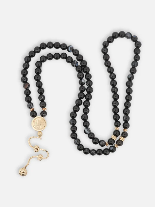 925 ayar gümüş altın kaplama detaylı, siyah akik taneli 99’lu tesbih; şerit formlu imame içerisinde Kabe örtüsü ve Allah lafzı bulunan döner mekanizma.