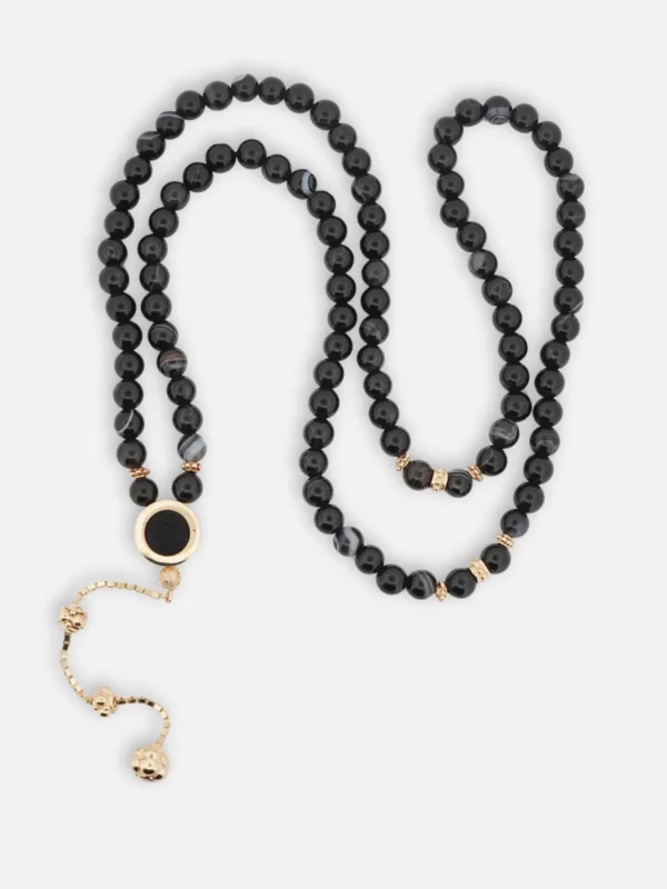 925 ayar gümüş altın kaplama detaylı, siyah akik taneli 99’lu tesbih; şerit formlu imame içerisinde Kabe örtüsü ve Allah lafzı bulunan döner mekanizma.