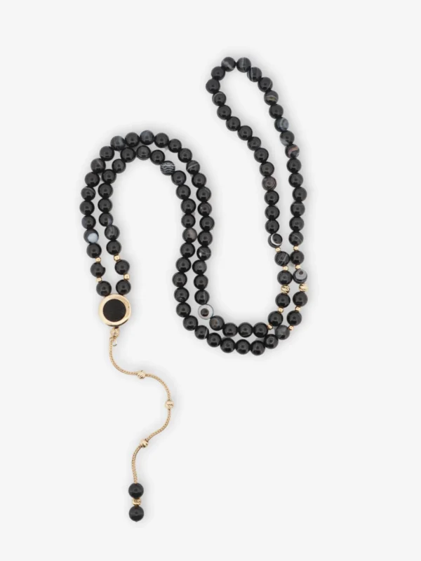 925 ayar gümüş, altın kaplama detaylı, 99 taneli siyah akik taşlı ve imamesinde orijinal Kâbe örtüsü bulunan vavlı kordon tasarımlı tesbih.