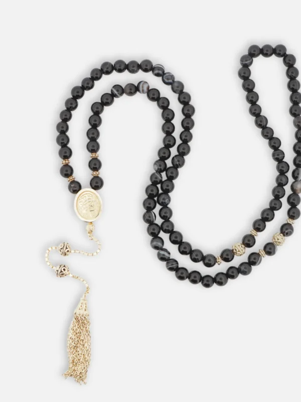 925 ayar gümüş altın kaplama oval hazneli imameye sahip siyah akik tesbih; imame içerisinde çift taraflı döner hat sanatı ve sanatsal doku detayı.