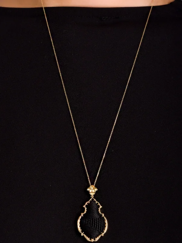 925 ayar gümüş üzerine altın kaplama, Osmanlı kandil formunda, merkezinde orijinal Kabe örtüsü (Kiswa) parçası bulunan taşlı kolye.