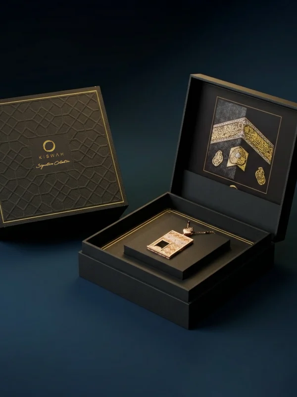 18 ayar altın pırlantalı kolye; Kabe kapısı formu üzerinde geleneksel hat sanatı ve geometrik kabartmalar.